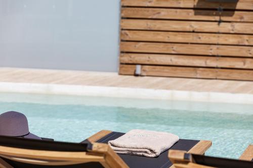 a chair with a towel on it next to a swimming pool at Eveland Accessible Villas in Sfakaki