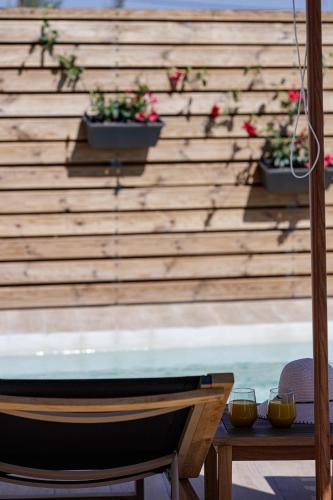 a bench and two glasses on a table with flowers at Eveland Accessible Villas in Sfakaki