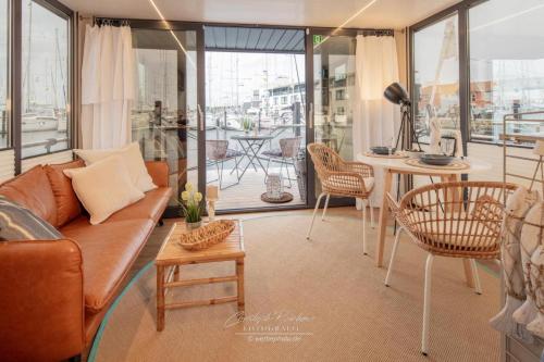a living room with a couch and chairs and a table at Hausboot Seepferdchen in Heiligenhafen