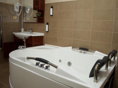 a bath tub in a bathroom with a sink at Hotel EMD in Bacău