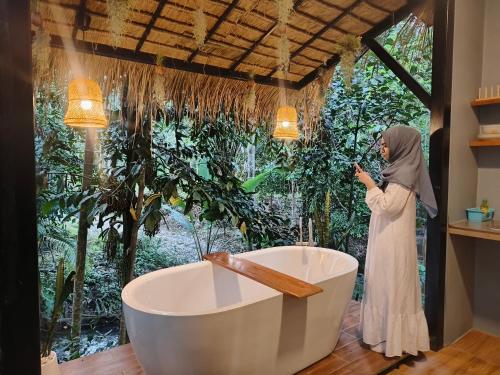 a woman taking a picture of a bath tub at Ingtara at Lanta in Ko Lanta