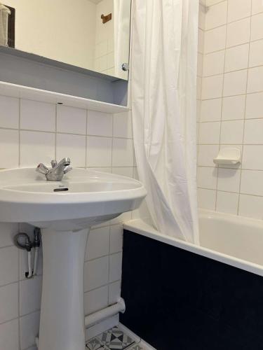 une salle de bain blanche avec un lavabo et une douche dans l'établissement SP150-003 Appt Studio 4 couchages SAINT PIERRE LA MER, à Saint Pierre La Mer