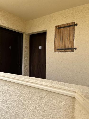 une chambre avec deux portes et une fenêtre dans l'établissement SP150-003 Appt Studio 4 couchages SAINT PIERRE LA MER, à Saint Pierre La Mer