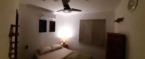 a bedroom with a bed and a ceiling fan at Chalé Pé na Areia e Piscina Privativa em Barra do Jacuípe in Camaçari