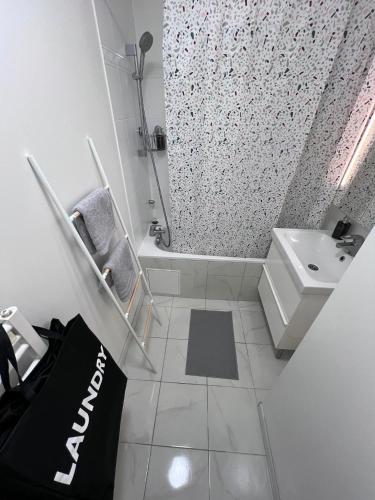 une salle de bain blanche avec un lavabo et une douche dans l'établissement T3, stade de France, Paris et Parking, à Saint-Denis