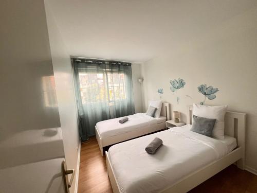 une petite chambre avec deux lits et une fenêtre dans l'établissement T3, stade de France, Paris et Parking, à Saint-Denis