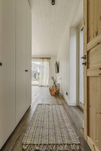 a hallway with a door and a rug on the floor at Svencelės burė 9 in Svencelė