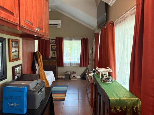 a kitchen with red curtains and a room with a bed at Captains Cabin on Lake in Jacksboro