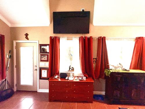 a living room with red curtains and a wooden dresser at Captains Cabin on Lake in Jacksboro