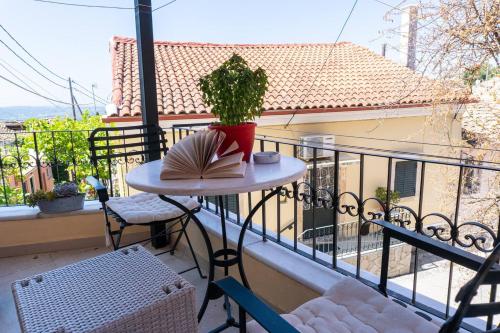 a table with a book and a plant on a balcony at Nina's Traditional House By Estia in Valaneíon