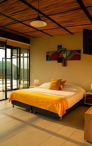 a bedroom with a large bed with yellow sheets at ketana - chalet turei g(4) in Sasaima