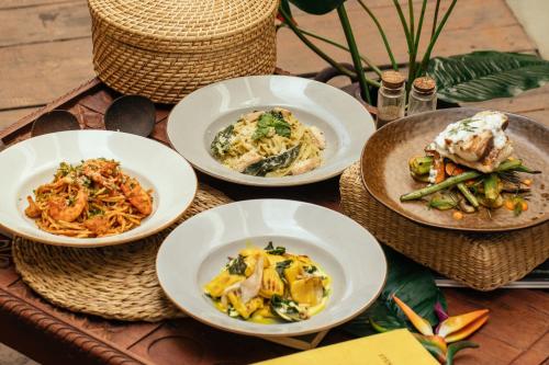 a table with four plates of food on it at Neevana Hotel Hikkaduwa in Hikkaduwa