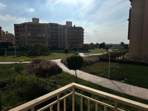 ein Gehweg, der zu einem großen Gebäude mit einem Park führt in der Unterkunft madinaty in Madinaty