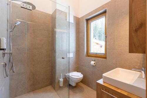 a bathroom with a shower and a toilet and a sink at Bergresort Tauernblick by ALPS RESORTS in Mittersill