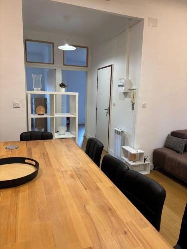 - un salon avec une grande table et des chaises en bois dans l'établissement Appartement T3 Square Bir-Hakeim, à Perpignan