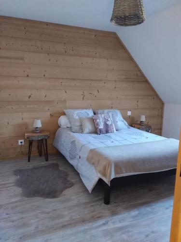 une chambre avec un grand lit avec un mur en bois dans l'établissement Maison a la montagne, à La Cabanasse