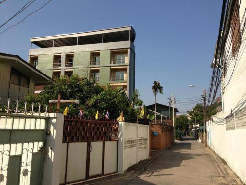 a fence with flags on it in front of a building at The State Apartment in Bangkok