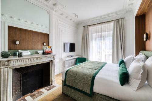 une chambre d'hôtel avec un lit et une cheminée dans l'établissement Oniri - Serviced Apartments in Louvre - Rue de Rivoli, à Paris