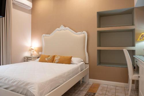 a bedroom with a white bed and a desk at Certosa Suite in Naples