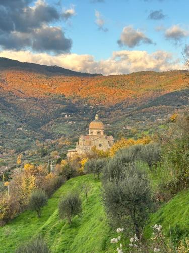 an old building on top of a hill with trees at Cortona Shabby Chic House in Cortona