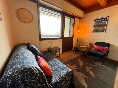 un salon avec un canapé et une fenêtre dans l'établissement Joli T3 ensoleillé, proche centre, avec balcon, parking et casier à ski - FR-1-624-89, à Samoëns