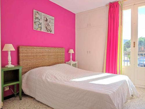 - une chambre avec un mur rose et un lit dans l'établissement Appartement 2 pièces 4 couchages ARGELES SUR MER AR670-1A4, à Argelès-sur-Mer