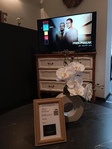 a room with a tv and a table with a sign at LA SUITE 159 in Namur