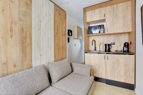 un salon avec un canapé et une cuisine dans l'établissement PARC MONCEAU - Beautiful apartment, à Paris