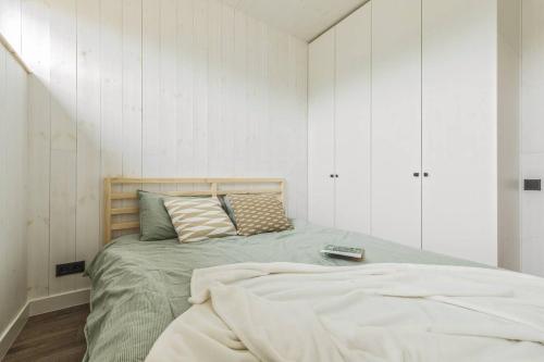1 dormitorio con 1 cama en una habitación con paredes blancas en Svencelės burė 10, en Svencelė