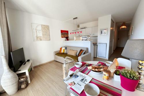 Il comprend un petit salon avec une table et une cuisine. dans l'établissement Renovated 2 room apartment - AC WIFI and terrace, à Grimaud