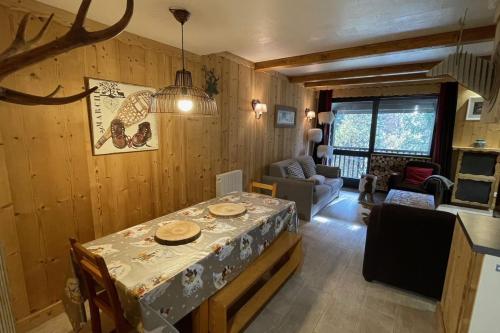 une salle à manger avec une table et un salon dans l'établissement Beautiful T2 near the slopes, à Saint-Chaffrey