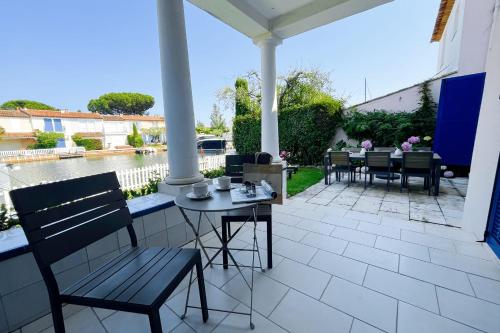 un patio avec une table et des chaises sur un patio dans l'établissement Wide house with WIFI and AC a terrace a garden and a 12m mooring, à Grimaud