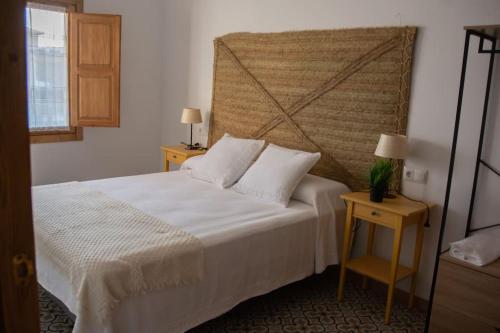 a bedroom with a white bed and two night stands at Casa Rural La Moreneta in Las Mesas