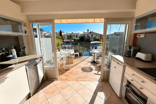 une cuisine avec une porte ouverte sur un patio dans l'établissement Renovated duplex apartment with AC and 2 terraces, à Grimaud