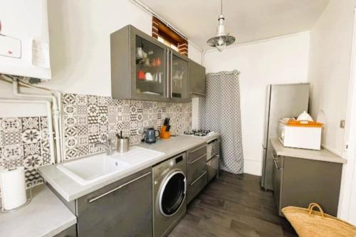 une cuisine avec un évier et une machine à laver dans l'établissement Nice house near hypercenter, à Trouville-sur-Mer