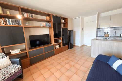 a living room with a couch and a television and a kitchen at This comfortable and bright apartment WIFI in Grimaud