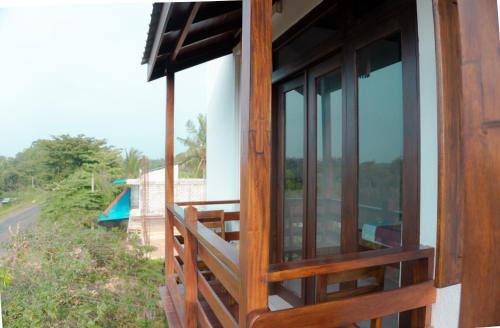 a balcony of a house with glass doors at Wilpattu Restaurant & Guest house in Pahala Maragahawewa