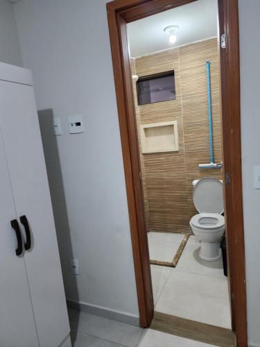 a bathroom with a toilet and a window at Apartamento para suas férias ou trabalho in João Pessoa