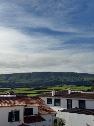 a view of roofs of houses with hills in the background at Oásis da Praia in Praia da Vitória