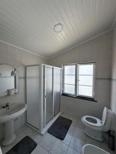 Un baño con ducha, inodoro y lavabo. en Oásis da Praia, en Praia da Vitória