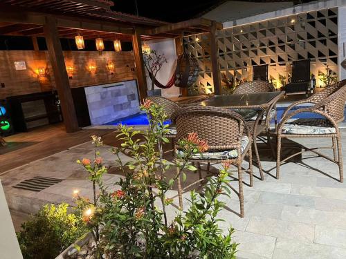 a patio with wicker chairs and a table and some plants at Beach House Itamaracá in Itamaracá