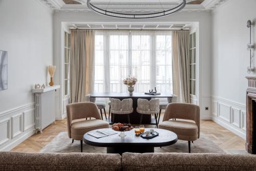 un salon avec un canapé, une table et des chaises dans l'établissement Oniri - Serviced Apartments in Louvre - Rue de Rivoli, à Paris