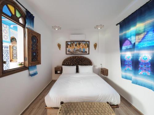 a bedroom with a white bed and a window at Palacio Del Sol in Chefchaouene