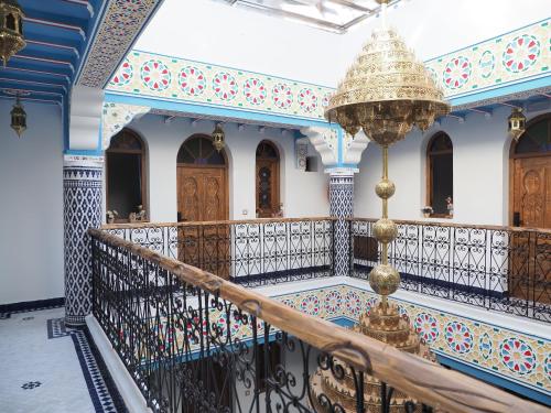 a staircase in a building with a chandelier at Palacio Del Sol in Chefchaouene