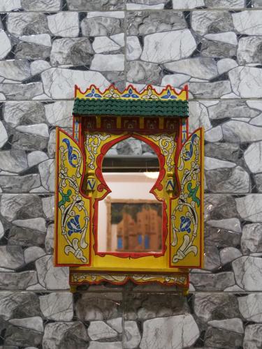 a colorful mirror on a stone wall at Palacio Del Sol in Chefchaouene