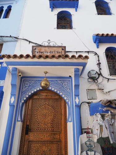 a blue and white building with a wooden door at Palacio Del Sol in Chefchaouene