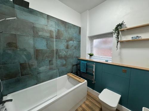 a bathroom with a bath tub and a toilet at Between the Beach and Shops 2 bath private parking in Portsmouth