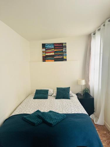 une chambre avec un lit avec des oreillers bleus dessus dans l'établissement Cozy flat heart of Paris, à Paris