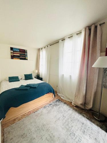 une chambre avec un lit et une grande fenêtre dans l'établissement Cozy flat heart of Paris, à Paris