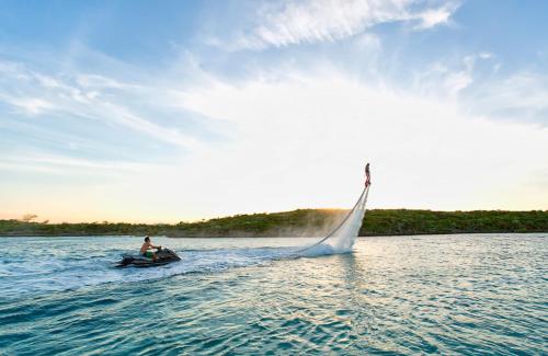 a man on a boat with a sail in the water at Anema Wellness & Resort Gili Lombok - Diving Center PADI in Tanjung